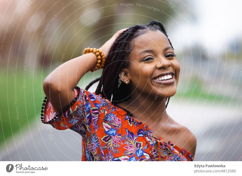 Portrait of a beautiful young woman in the city cool carefree confident day millennials dreadlocks enjoy authentic positive real people joyful toothy smile