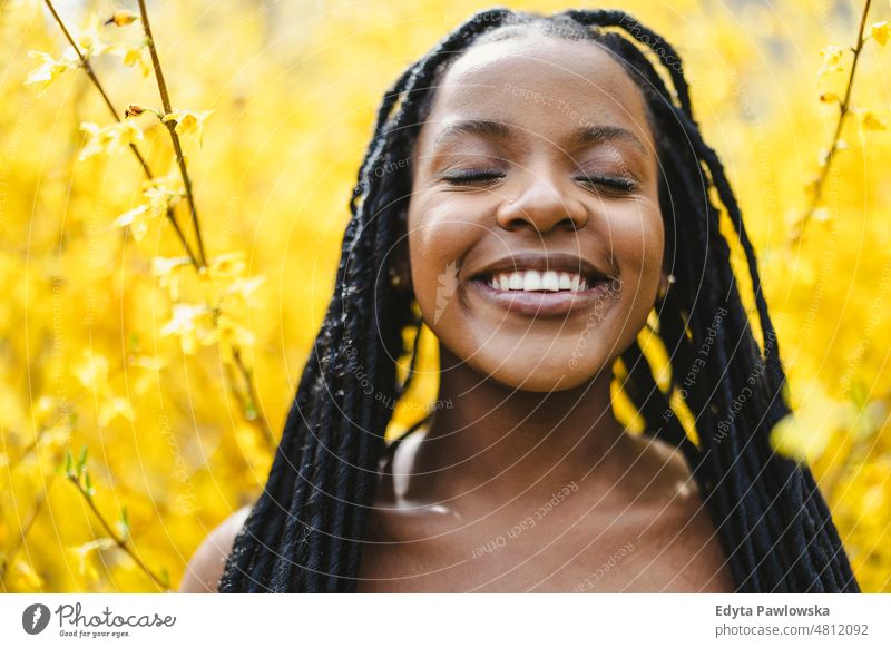 Beautiful young woman in spring flowers cool carefree confident day millennials dreadlocks enjoy authentic positive real people joyful toothy smile hairstyle