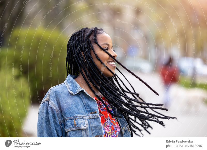 Portrait of a beautiful young woman in the city cool carefree confident day millennials dreadlocks enjoy authentic positive real people joyful toothy smile