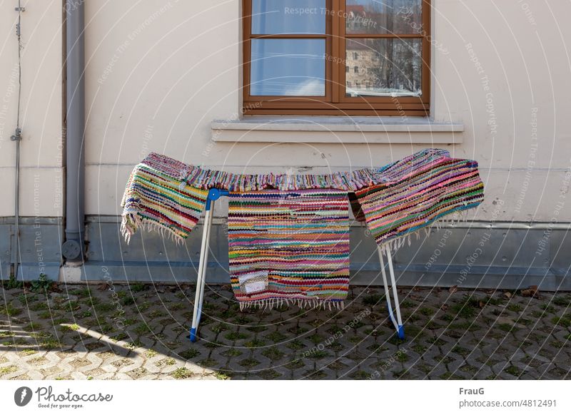 colorful | are the runners on the clothes horse House (Residential Structure) Wall (building) Facade Window reflection Downspout Lightning rod pavement Grass