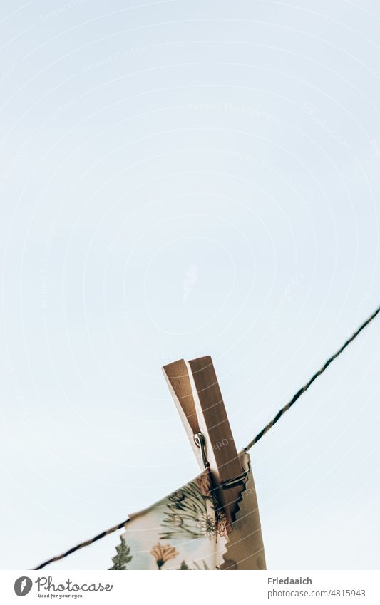 Clothesline with wooden clothespin and colorful cloth in front of cloudless sky Clothes peg clothesline Dry Hang Washing Exterior shot Minimalistic