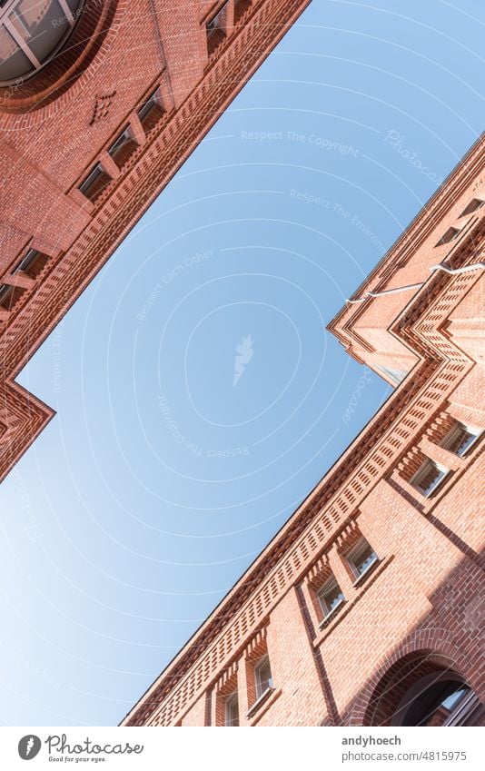 Two modernized brick houses facing each other with blue sky above aged ancient architecture Berlin brickwork building clean clear construction copy space design