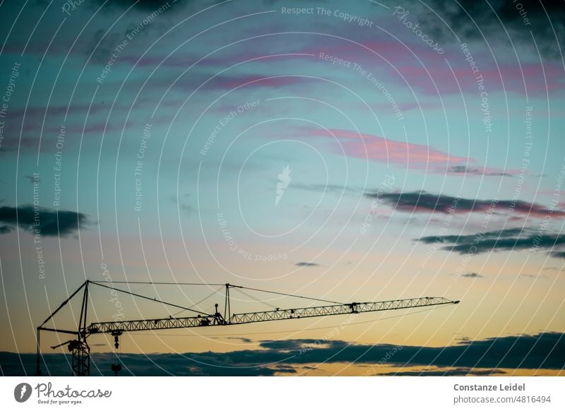 Boom of a crane in front of colorful evening sky. Sky Sunset Closing time Twilight Evening Copy Space Sunset sky sunset mood Landscape Light Clouds