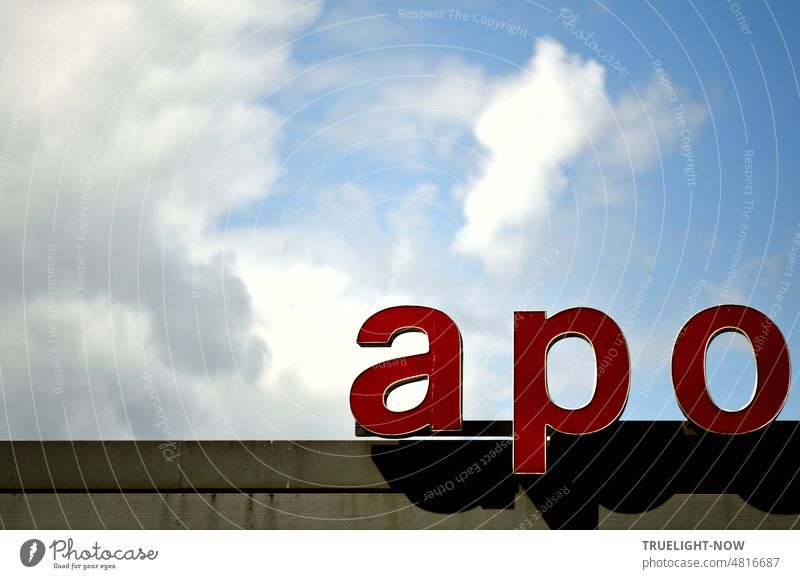 [Hansa BER 2022] The APO is not dead to get! Part of a pharmacy neon sign in large small red letters on the flat roof of a building in front of summer blue cloudy sky