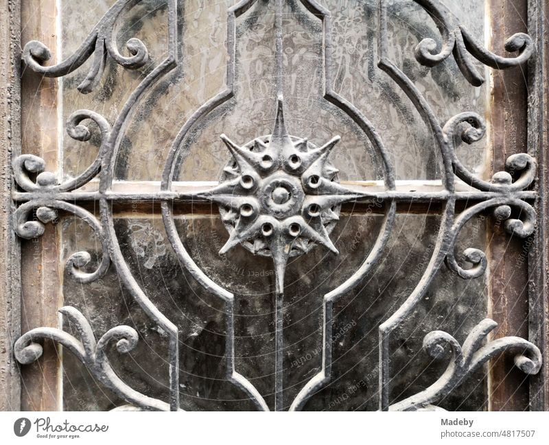 Old front door of brown wood with decoratedglass and wrought iron of a run-down old building in the district Sachsenhausen in Frankfurt am Main in Hesse Iron