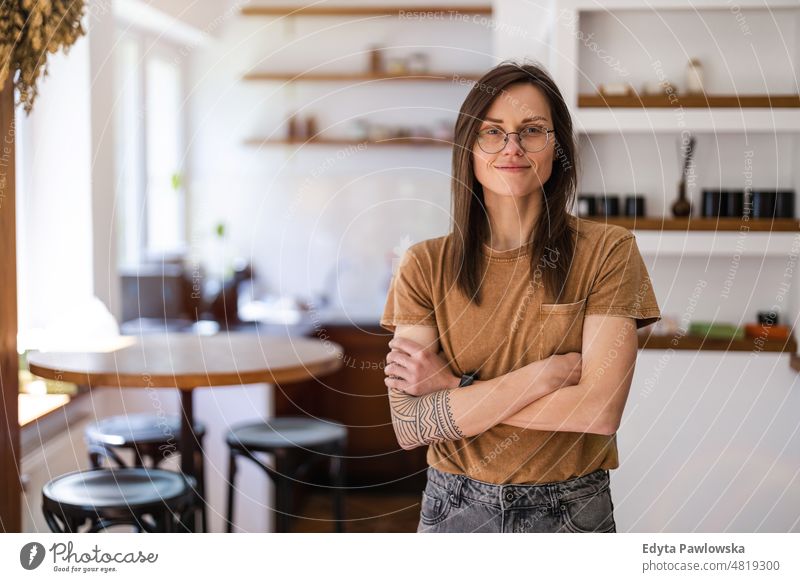 Portrait of a young woman standing in her home domestic life confidence indoors house people adult casual female Caucasian attractive beautiful tattoos one