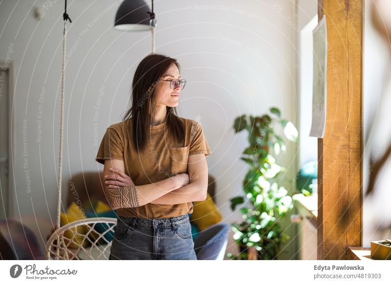 Portrait of a young woman standing in her home domestic life confidence indoors house people adult casual female Caucasian attractive beautiful tattoos one