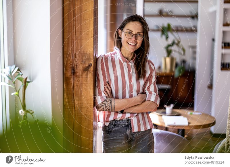 Portrait of a young woman standing in her home domestic life confidence indoors house people adult casual female Caucasian attractive beautiful tattoos one