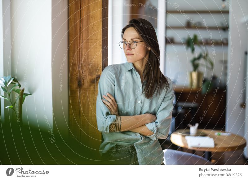 Portrait of a young woman standing in her home domestic life confidence indoors house people adult casual female Caucasian attractive beautiful tattoos one