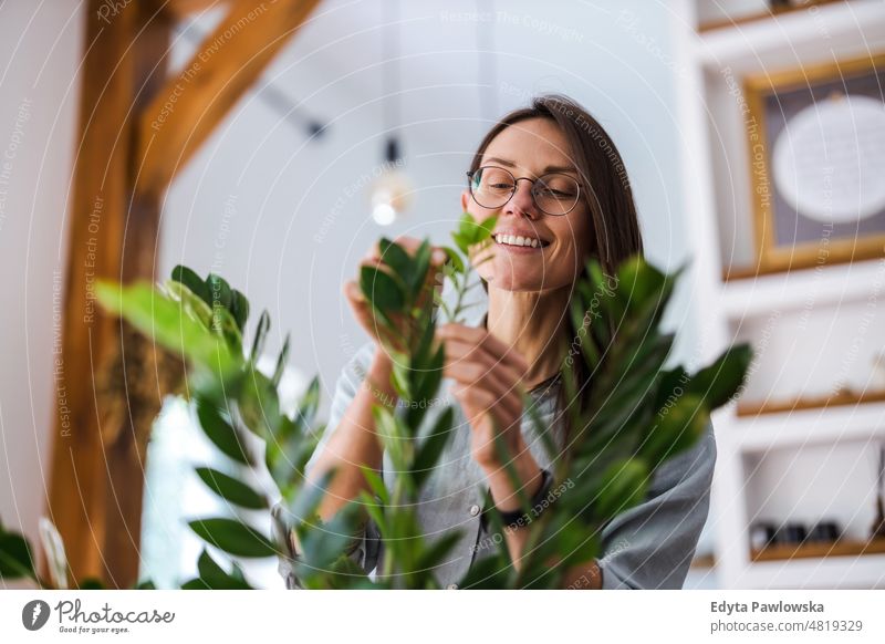 Young woman taking care of her houseplants potted green nature leaves freshness hobby grow flowerpot gardening florist relaxation simple living potted plant