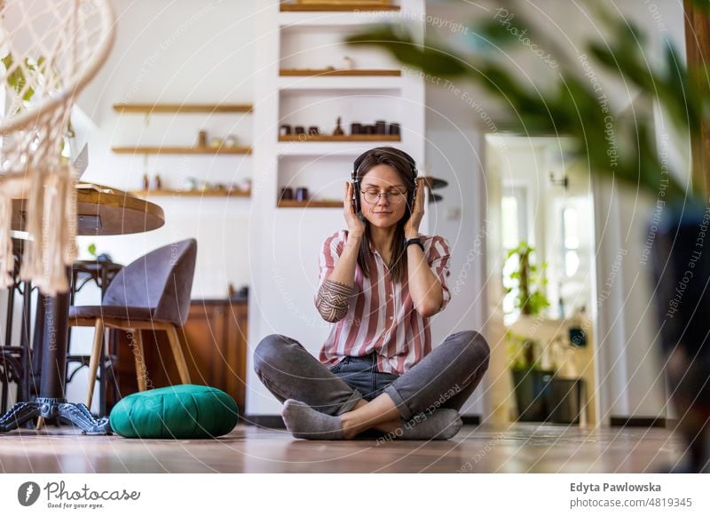 Relaxed young woman sitting on the floor at home domestic life confidence indoors house people adult casual female Caucasian attractive beautiful tattoos one