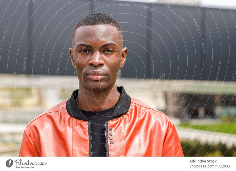 Confident young black guy standing on street in sunlight man millennial confident city self assured serious personality style appearance generation z