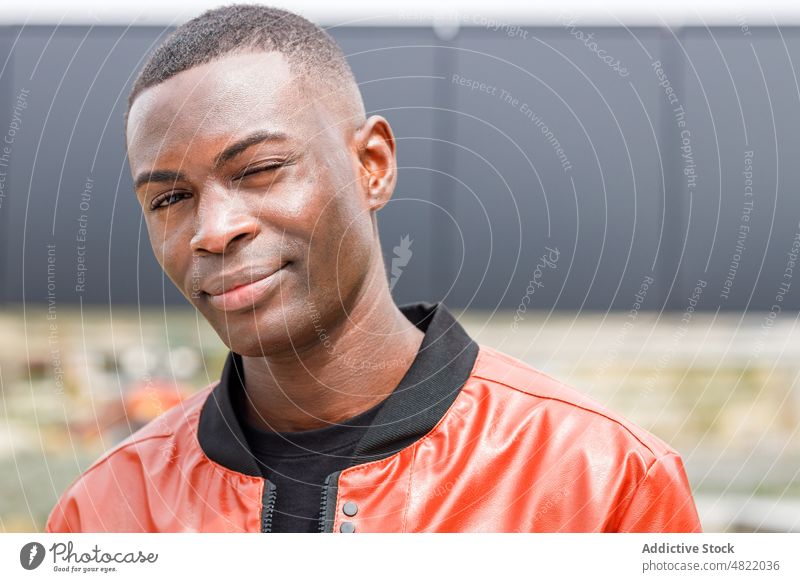 Confident young black guy standing on street in sunlight man millennial confident city self assured personality style appearance generation z charismatic happy