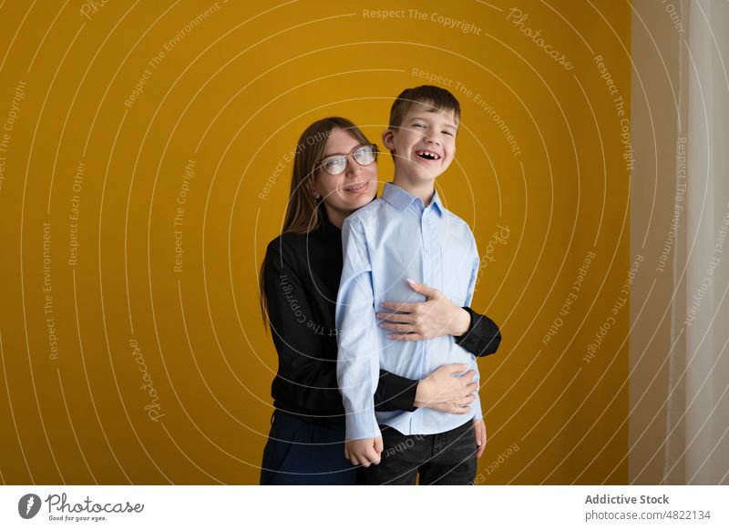 Loving mother hugging happy son love smile home together relationship portrait woman boy smart casual bright glasses positive optimist glad fondness affection