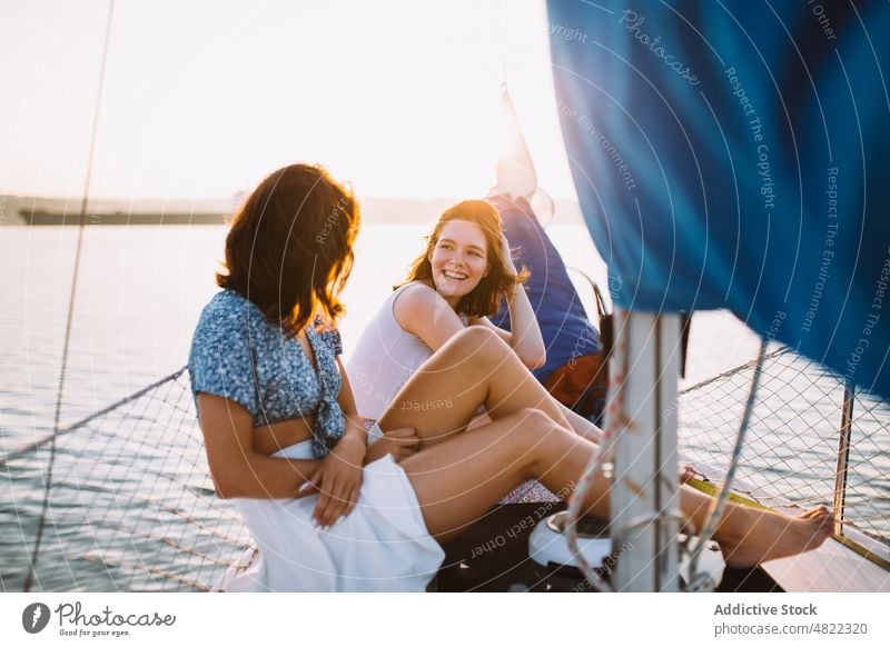 Happy ladies chatting during cruise on sea at sunset women sailboat friend summer vacation together yacht happy smile talk relax trendy young holiday cheerful