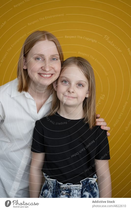 Happy kid with young mother embracing each other looking at camera woman child smile happy daughter embrace love together bonding home relationship preteen