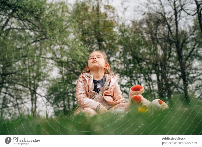 Cute little girl with teddy bear resting on grass with closed eyes eyes closed relax lawn nature toy child park childhood adorable innocent cute kid