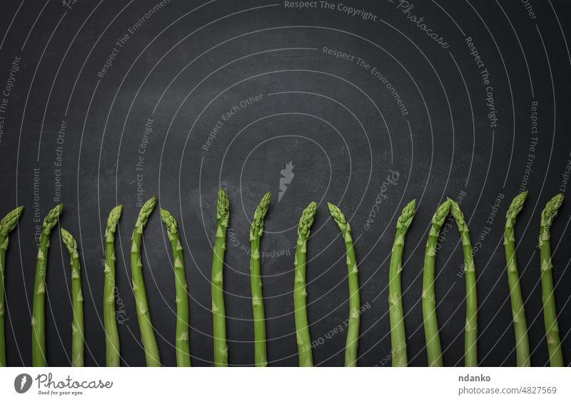 Bunch of fresh raw asparagus on a wooden black kitchen board, a healthy product closeup cook cookery cooking diet epicure food freshness germinating green