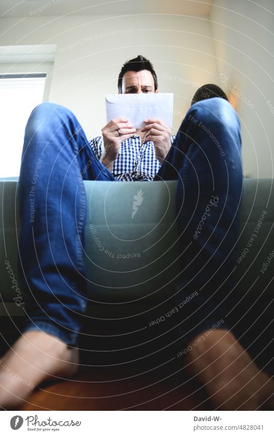 Post - man looks skeptically at a letter news Letter (Mail) open anxiously Bad Negative Invoice Envelope (Mail) Communication Man Facial expression