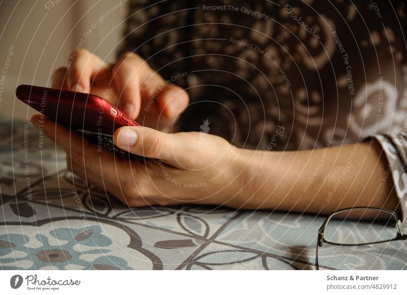 Woman sitting at table typing on her smartphone Eyeglasses eyeballed tablecloth Chat whatsapp Cellphone Communicate Surfing Internet Telephone SMS Media