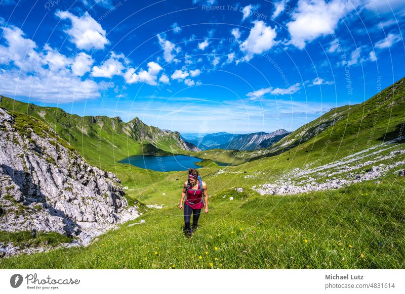 Woman hiking to box head Alps mountain mountains mountain lake flowers Germany behind the stone Hut Light Paradise Protection Lake Sun Tyrol Meadow Allgäu