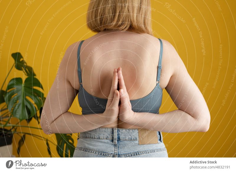 Crop anonymous woman preforming Reverse Prayer Yoga pose in studio reverse prayer yoga paschim namaskarasana stress relief meditate zen balance wellbeing