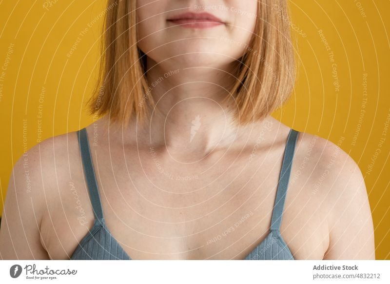 Anonymous young lady in bra standing against yellow background woman confident model positive optimist individuality female ginger hair jeans redhead