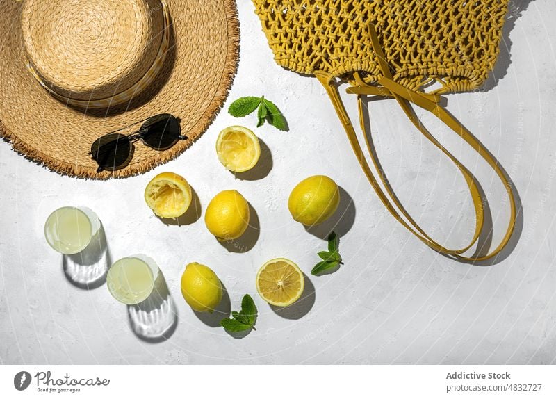 Flat lay of summer concept composition lemon fresh natural healthy creative organic sunglasses drinks hat yellow color shadow sunlight mint bright fruit vivid