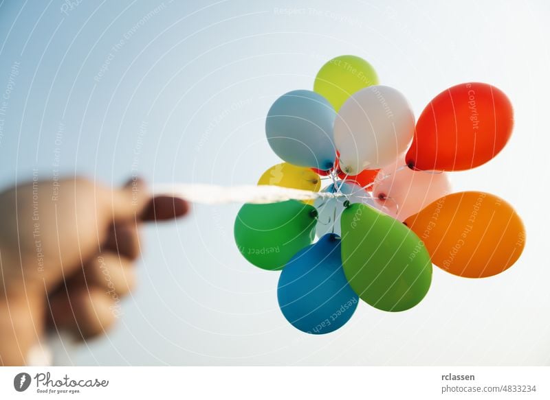 hand holding Colorful balloons at a funfair ballon birthday party celebration colorful latex dreams blue bunch celebrate childhood concept creative sunlight