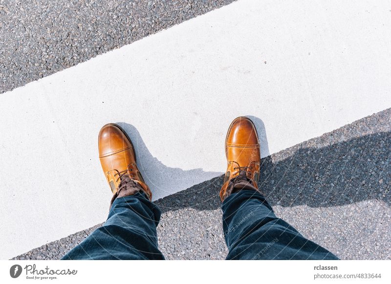 Man standing on grunge asphalt city street with white line and copy space, point of view perspective pov conceptual floor sign urban step ground legs adventure