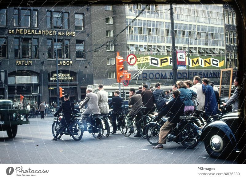 Bicyclers on the Streets of Amsterdam in Holland Netherlands Travel Tourism Biking Transportation Historic Architecture Exterior Shot Bikes Europe Downtown