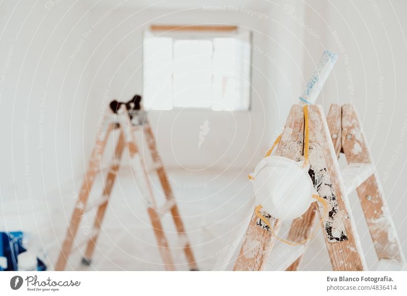 ladders and painter tools on white room at construction site. Painting walls. Home improvement works renovation home house colors interior roller grey painting