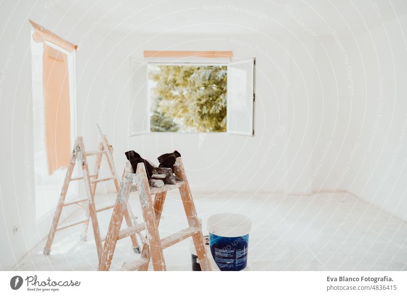 ladders and painter tools on white room at construction site. Painting walls. Home improvement works renovation home house colors interior roller grey painting