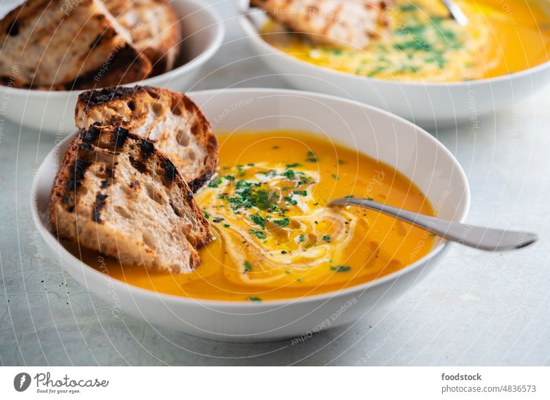 Pumpkin soup served in a bowl with croutons, parsley and olive oil. autumn bread carrot coconut milk cream cuisine delicious diet dinner dish eating fall food