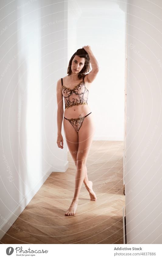 Provocative woman in underwear standing on corridor lingerie sensual allure seductive provocative sexy seduce figure feminine style slim hallway female slender