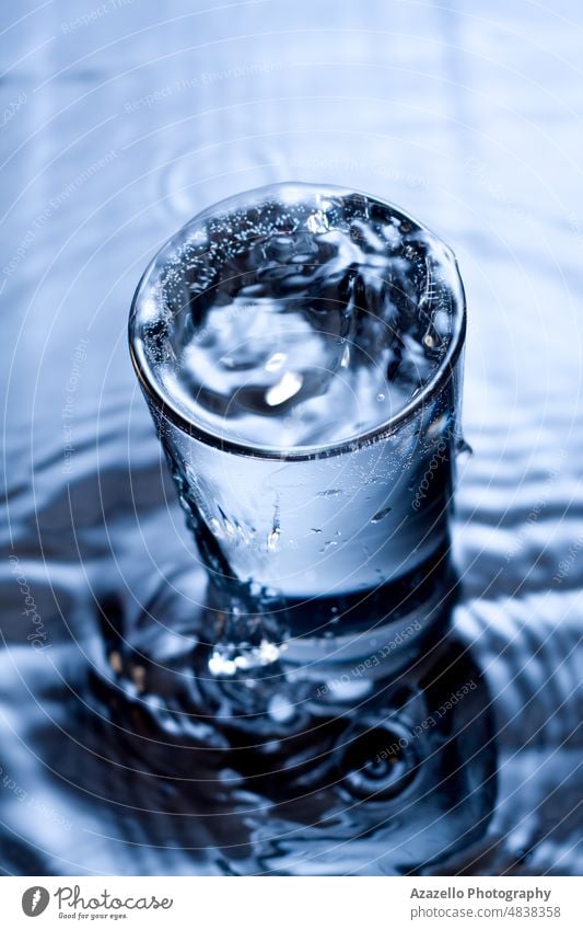 Blue monochrome image of water splashing in a glass. Water aqua background beverage black blue blur blurry bubble clean clear cold concept cool dark diet drink