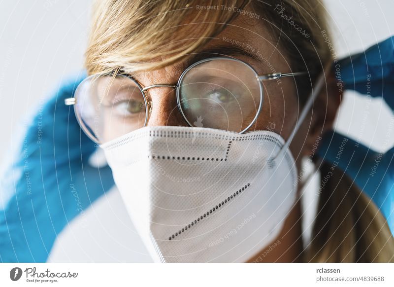 Woman wearing N95 FFP2 an anti virus protection mask and glasses are fogged up to prevent others from corona COVID-19 and SARS cov 2 infection covid woman