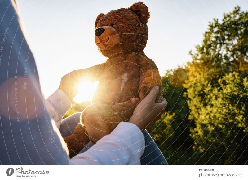 Woman holding teddy bear toy with sunlight at sunset back adult alone path beautiful sad beauty walkway girl body sun flare caucasian cute female hugging forest