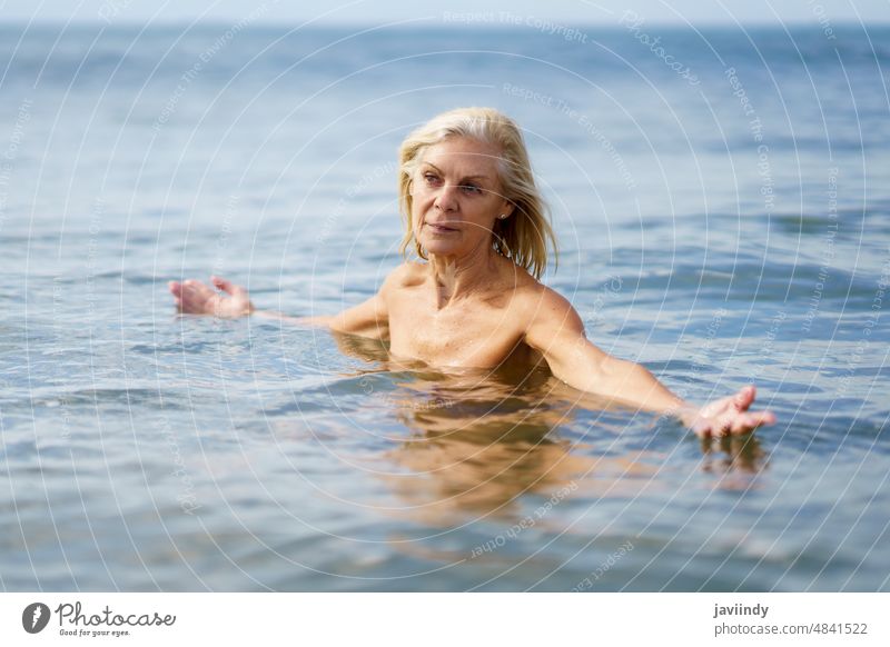 Eldery woman in good shape bathing in the sea. mature beach swim active swimming senior old water person summer nature vacation female lifestyle healthy