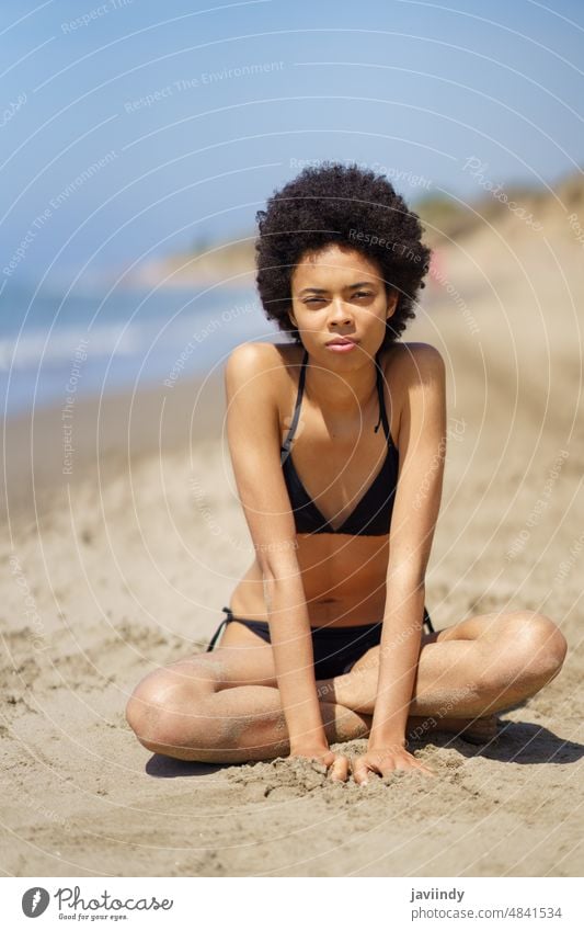 Black woman in bikini on sandy seashore beach summer serious recreation tropical trip female black african american ethnic coast swimwear resort lady seacoast