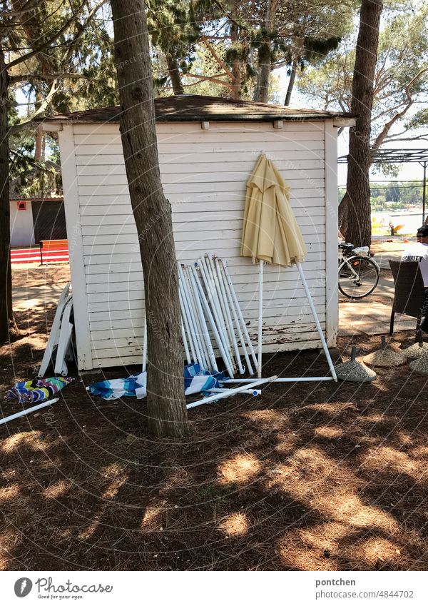 A beach hut. Parasols, umbrella stands. Clutter Ocean Sunshade sunshade stand disorder rental Vacation & Travel Shadow trees Tourism