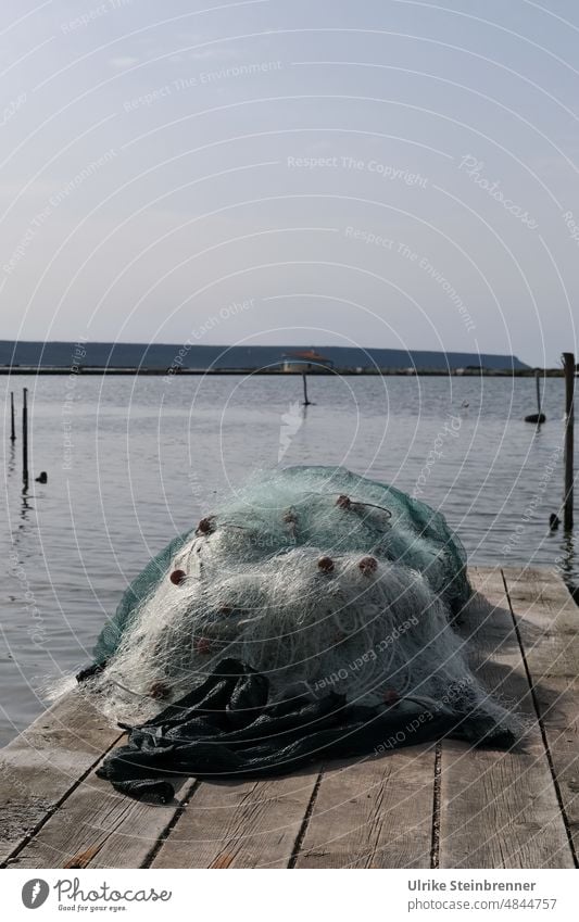 Fishing nets wait for their use on the wooden jetty Net fishing Network Safety gear Fishery Fishing port Harbour Maritime wooden walkway Footbridge storage