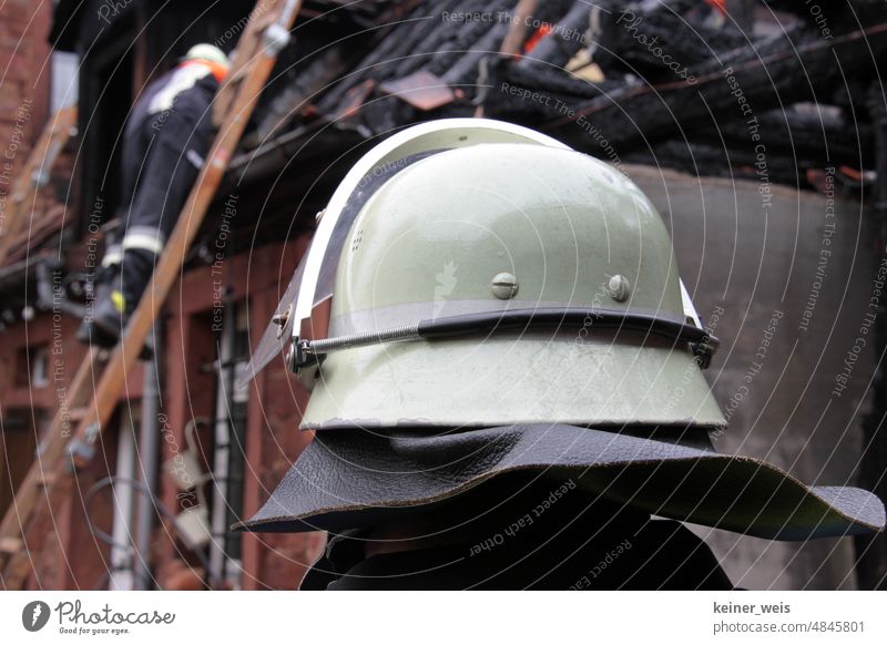 A firefighter anonymous with firefighter helmet in firefighting operation at a building fire Fireman Blaze fireman's helmet Building fire house fire