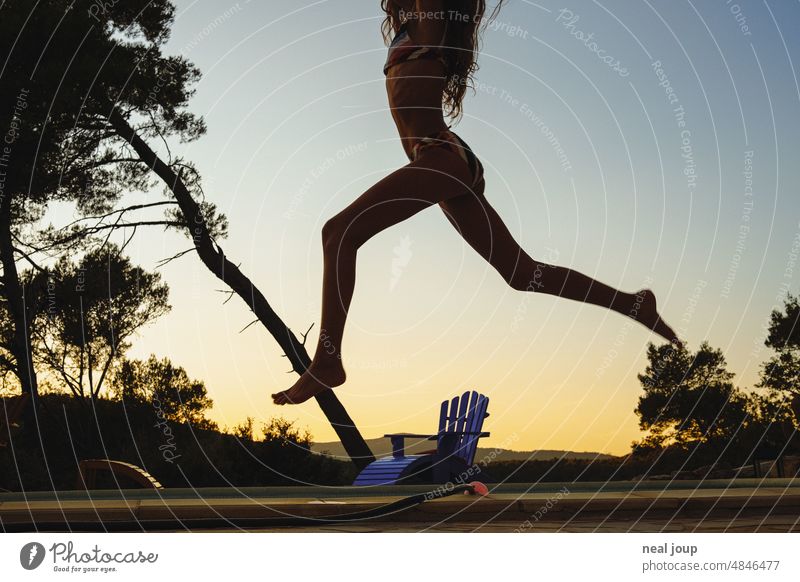 Silhouette of girl happily jumping in front of evening sky human silhouette Girl Summer pool Evening Twilight cheerful fun Dance Movement Swing Jump Hop warm