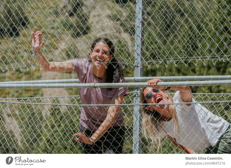 Two fun friends on the Tibetan Bridge in Andorra. adventure alps andorra andorra la vella architecture attraction background blue bridge building canillo europe