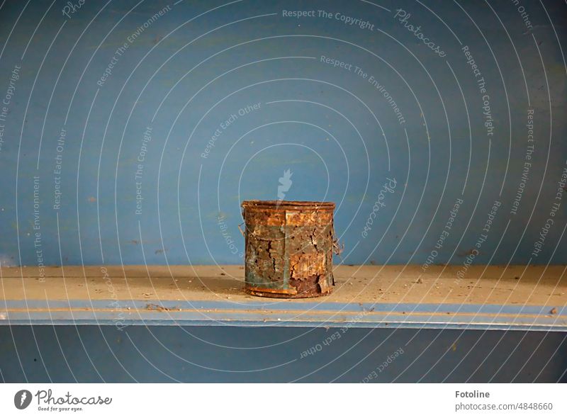 An old rusted tin can stands on a blue shelf in a lost place Tin Tin of food Colour photo Metal Interior shot Old Rust rusty corroded Brown Close-up Detail