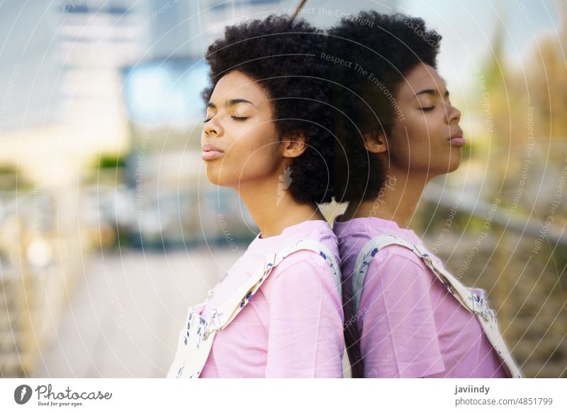 Thoughtful African-American woman with her eyes closed. relaxation mindfulness tranquility thoughtful pensive black curly person girl outdoors young hair