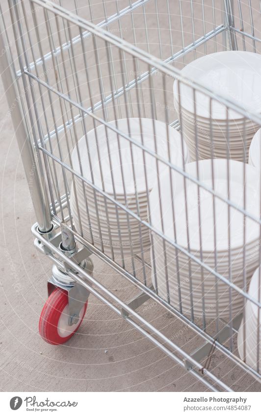 Clean white plates in a metal cart. aluminum stack dish pastel minimalism restaurant idea concept still life tableware kitchen wheel many clean group dishware