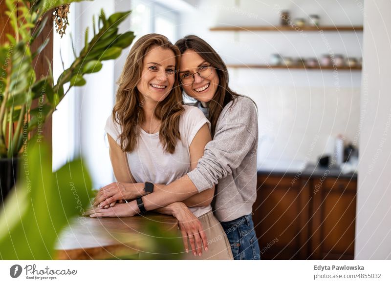 Portrait of affectionate lesbian couple embracing at home same sex couple adult apartment attractive beautiful bonding dating couple enjoyment family female