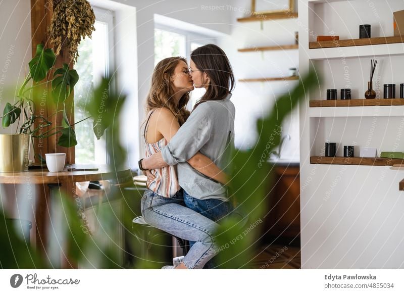 Lesbian couple kissing in their home same sex couple adult apartment attractive beautiful bonding dating couple enjoyment family female gay couple gay women